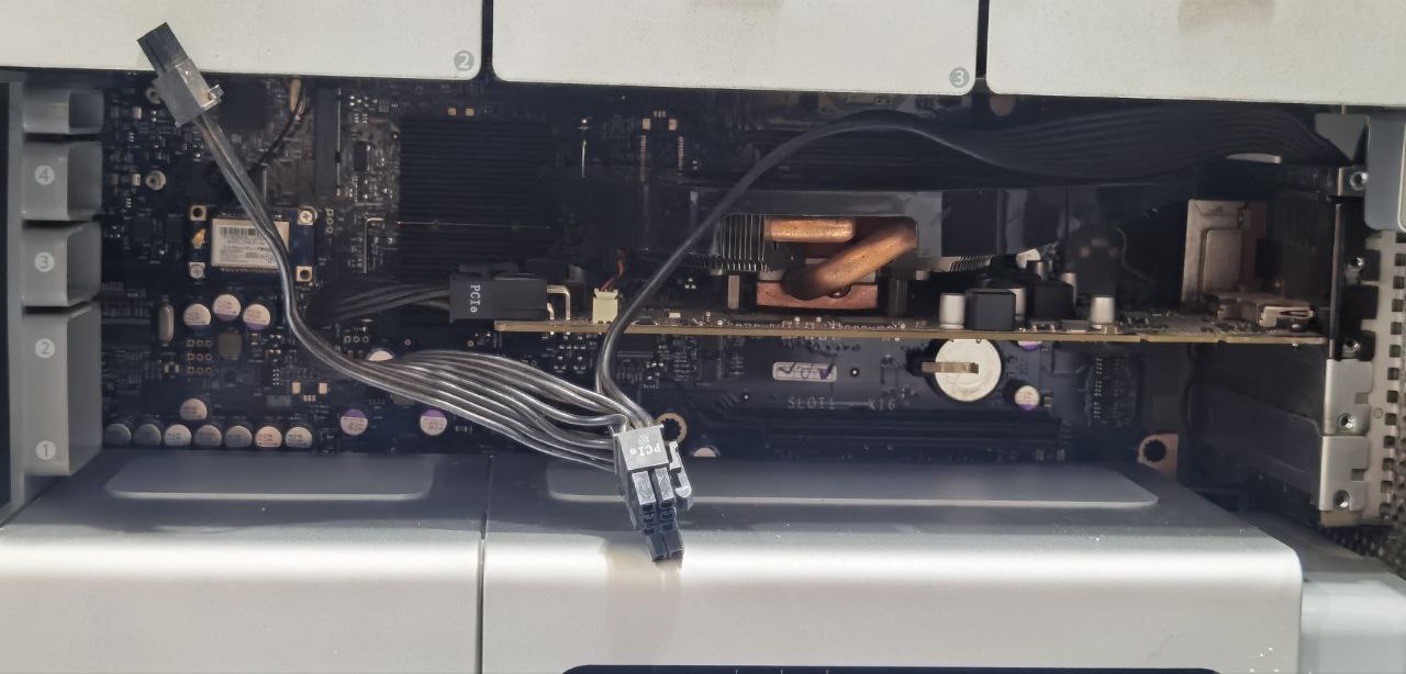 a graphics card installed on the pci slot of a mac pro, with the power cable of the graphics card going outside of the computer